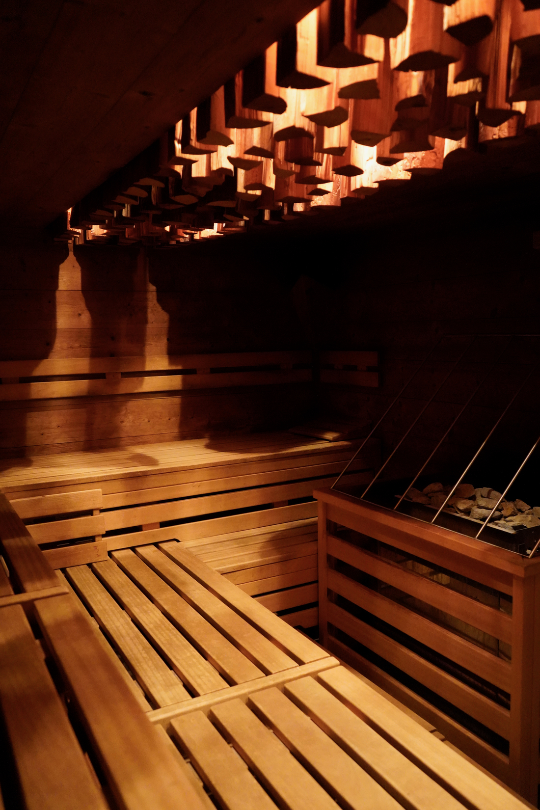 Leere Sauna aus hellem Holz mit faszinierender Deckenstruktur und warmem Licht